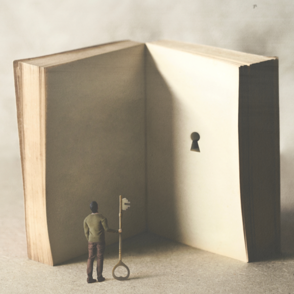 a man in miniature holds a key, gazing at a large open book with key hole on it's page