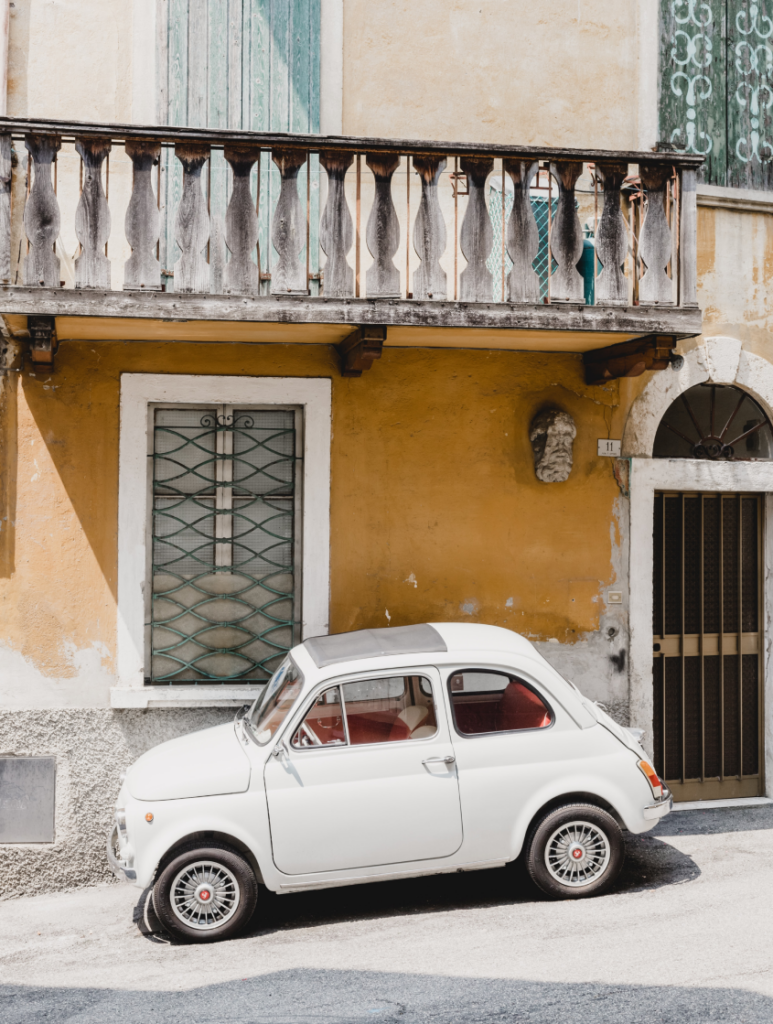 a little white Fiat on an old Italian street